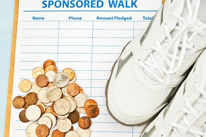 innovatives Kongresssponsoring mit Geld und weißen Turnschuhen auf einem Formular mit der Aufschrift sponsored walk